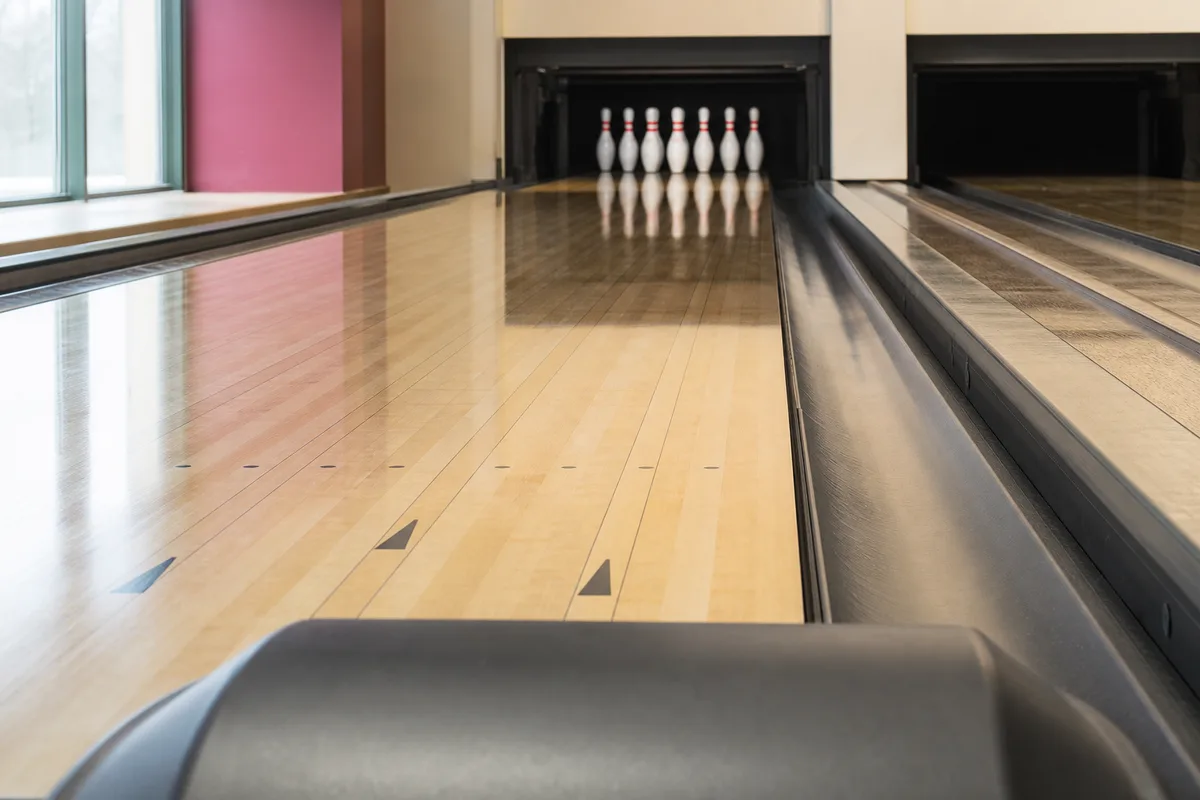 Piste de bowling vide avec le retour de boule au premier plan