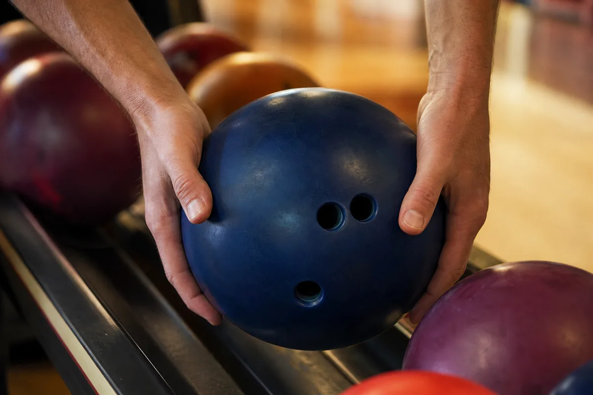 Mains d un joueur reposant une boule sur le retour de boule